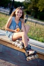 Smiling roller girl sitting on the bench