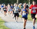 Smiling runners racing around Belmont Lake during 5K Race