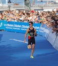 Smiling running triathlete Joao Pereira fighting at the finish