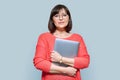 Smiling 40s woman with laptop on gray color background Royalty Free Stock Photo