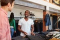 Smiling Sales Assistant Helping Male Customer To Buy Clothes In Fashion Store Royalty Free Stock Photo