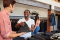 Smiling Sales Assistant Helping Male Customer To Buy Clothes In Fashion Store Royalty Free Stock Photo