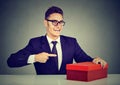 Smiling salesman young business man advertising his product in red box