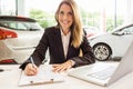 Smiling saleswoman writing on a clipboard