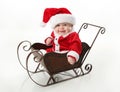 Smiling santa baby sitting in a sleigh Royalty Free Stock Photo