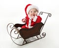 Smiling santa baby sitting in a sleigh Royalty Free Stock Photo