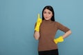Smiling satisfied delighted asian houseworker wearing yellow gloves and pointing finger upward