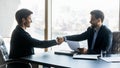 Smiling satisfied hr manager shaking successful candidate hand after interview