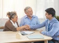 Smiling satisfied senior couple making sale purchase deal concluding contract hand get house key from real estate agent,happy Royalty Free Stock Photo