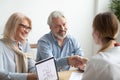 Happy older family and realtor shake hands buying new house