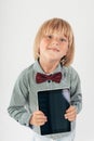 Smiling School boy in shirt with red bow tie, holding tablet computer and green apple in white background Royalty Free Stock Photo