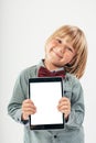 Smiling School boy in shirt with red bow tie, holding tablet computer and green apple in white background Royalty Free Stock Photo