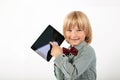 Smiling School boy in shirt with red bow tie, holding tablet computer and green apple in white background Royalty Free Stock Photo