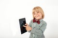 Smiling School boy in shirt with red bow tie, holding tablet computer and green apple in white background Royalty Free Stock Photo