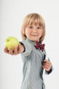 Smiling School boy in shirt with red bow tie, holding tablet computer and green apple in white background Royalty Free Stock Photo