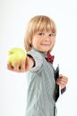 Smiling School boy in shirt with red bow tie, holding tablet computer and green apple in white background Royalty Free Stock Photo