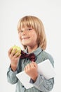 Smiling School boy in shirt with red bow tie, holding tablet computer and green apple in white background Royalty Free Stock Photo