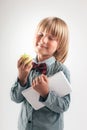 Smiling School boy in shirt with red bow tie, holding tablet computer and green apple in white background Royalty Free Stock Photo