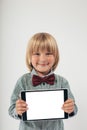 Smiling School boy in shirt with red bow tie, holding tablet computer in white background