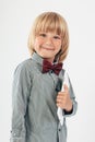 Smiling School boy in shirt with red bow tie, holding tablet computer in white background Royalty Free Stock Photo