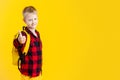 Schoolboy holding backpack  on yellow Royalty Free Stock Photo