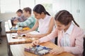 Smiling schoolgirl doing homework in classroom Royalty Free Stock Photo