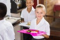 Smiling schoolgirl holding food tray in school cafeteria Royalty Free Stock Photo