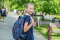 Smiling schoolgirl preteen goes to school with backpack and drink. Concept of back to school