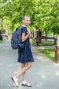 Smiling schoolgirl preteen goes to school with backpack and drink. Concept of back to school