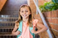 Smiling schoolgirl standing on staircase