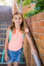 Smiling schoolgirl standing on staircase