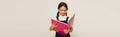 smiling schoolkid reading copy book while