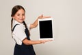 smiling schoolkid showing digital tablet with