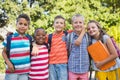 Smiling schoolkids standing with arms around in campus Royalty Free Stock Photo