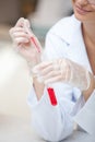 Smiling scientist holding pipette and test tube