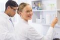 Smiling scientist looking at camera and holding a beaker