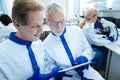 Smiling scientists discussing DNA results displayed on a tablet Royalty Free Stock Photo