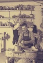 Smiling sculptor making pot using pottery wheel Royalty Free Stock Photo