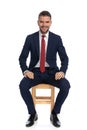 Smiling seated businessman in suit smiling while posing in studio
