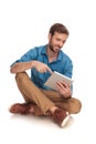 Smiling seated casual man touching the screen of his tablet Royalty Free Stock Photo