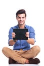 Smiling seated man showing the screen of his tablet Royalty Free Stock Photo