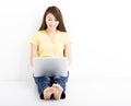 Smiling seated young woman with laptop