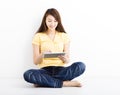 Smiling seated young woman with tablet pc