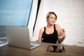 Smiling secretary reading e-mail letter on cellphone during work on laptop computer. Royalty Free Stock Photo