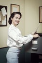 Smiling secretary searching files in the filing cabinet