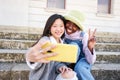 Smiling selfie of Two cheerful female friends having fun. Interracial Couple taking picture with smart mobile Royalty Free Stock Photo