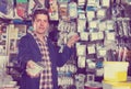 Smiling seller in hardware store is trading sockets