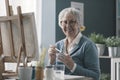 Smiling senior artist posing in her studio