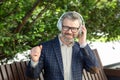 Confident senior businessman enjoying music outdoors in suit and headphones Royalty Free Stock Photo