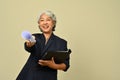 Smiling senior businesswoman wearing black suit and eyeglasses posing isolated on beige background Royalty Free Stock Photo